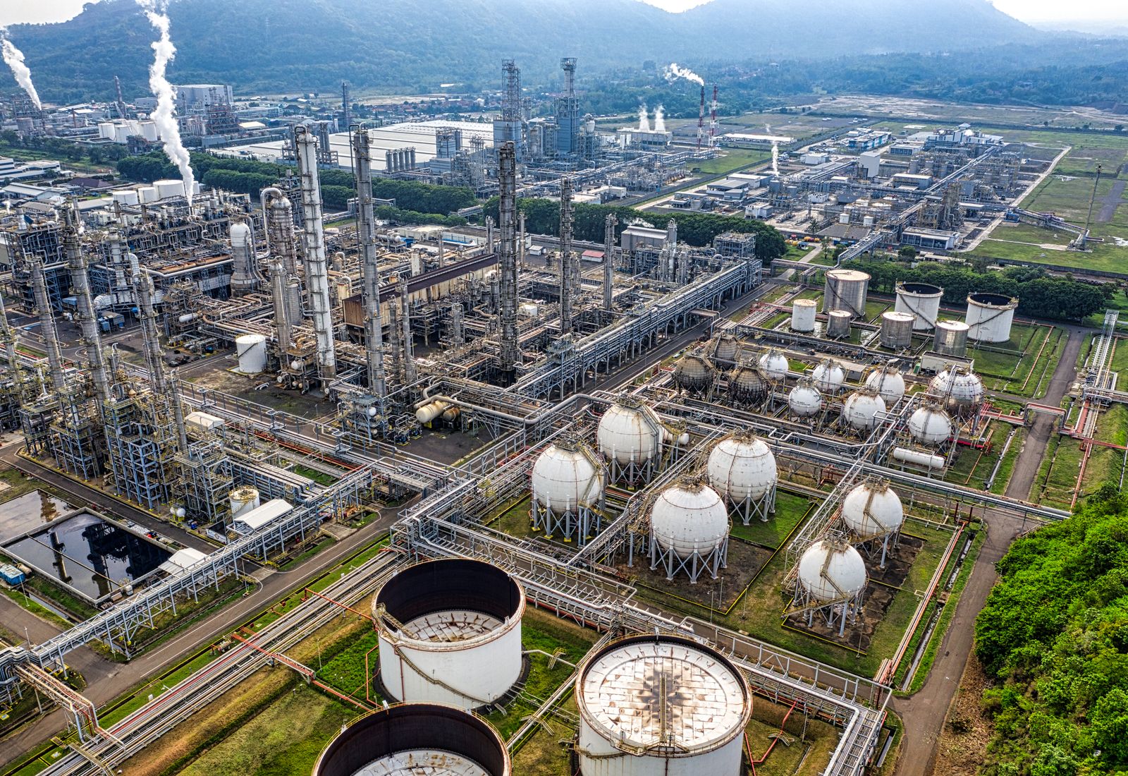 Aerial view of a processing plant with storage spheres and tanks